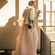 A photo of Christie heading out of their apartment in her wedding dress, bouquet in hand.